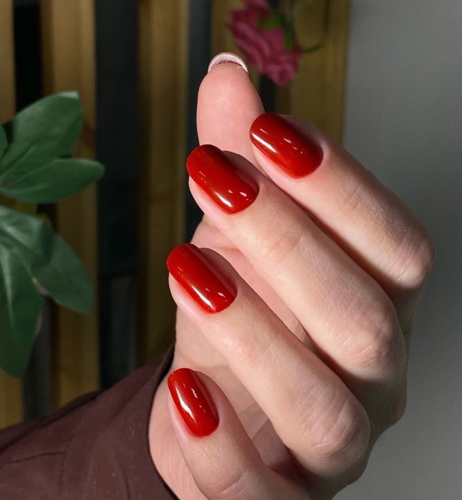 Классический красный маникюр гель-лаком в Салоне красоты Мускат Архангельск. Глянцевое однотонное покрытие на овальных ногтях. Яркий и стильный маникюр для осени или зимы.